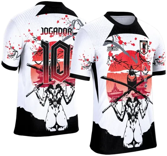 Camisa branca e preta com arte estilo samurai, na frente círculo vermelho com paisagem japonesa e galhos de cerejeira, escudo JAPAN JFA e texto SOCCER; costas mostram samurai segurando katanas com texto JOGADOR e número 10 em degrade vermelho e preto