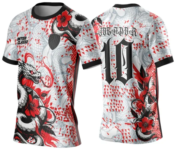 Camisa branca com estampa de serpente preta e branca enrolada em flores vermelhas na frente e número 10 preto ao centro das costas com texto MAJOR acima, detalhes em triângulos vermelhos e gola e punhos pretos.