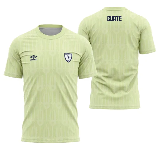 Camisa verde claro com padrão geométrico suave, escudo de Guatemala no peito esquerdo e logo umb ro. Nas costas, o nome GUATE em azul escuro destacando o design limpo e elegante.
