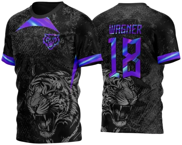 Camisa preta com textura grunge e estampa de tigre feroz cinza na frente e costas, logo pequeno do tigre roxo e azul no peito, mangas com faixa roxa e azul; nas costas nome WAGNER e número 18 em roxo e azul com efeito degradê.
