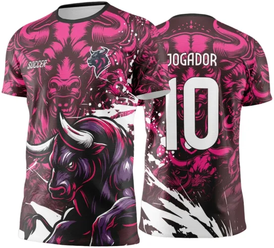 Camisa com figura frontal de touro agressivo em rosa, roxo e preto, escudo pequeno com touro na frente. Costas exibem número 10 e nome JOGADOR em branco, com fundo em rosa escuro e detalhes brancos contrastantes.