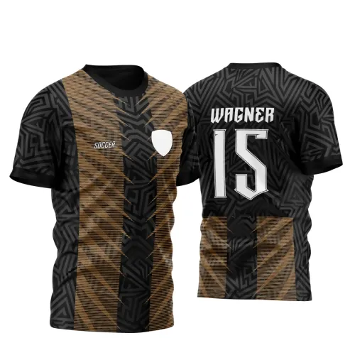Camisa preta com listras douradas verticais e padrão tribal na frente, incluindo escudo branco e texto Soccer. Nas costas, fundo preto com padrão tribal, nome Wagner e número 15 em branco, faixa dourada com detalhes listrados na parte inferior.