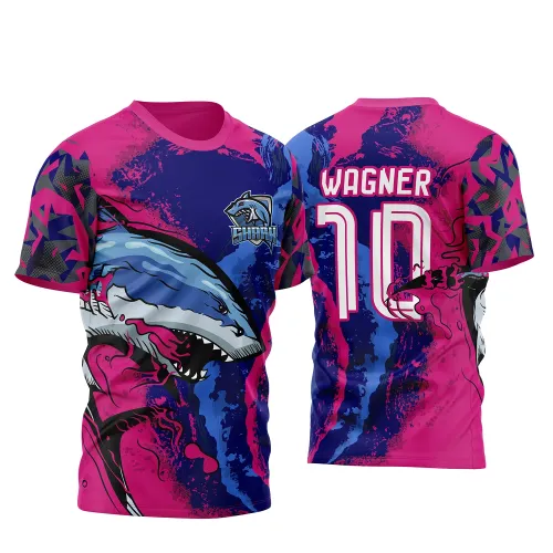 Camisa com tubarão azul agressivo na frente sobre fundo degradê em azul e rosa, escudo com texto SHARK; nas costas, nome WAGNER e número 10 em branco com contorno rosa, fundo colorido e mangas com padrão geométrico.
