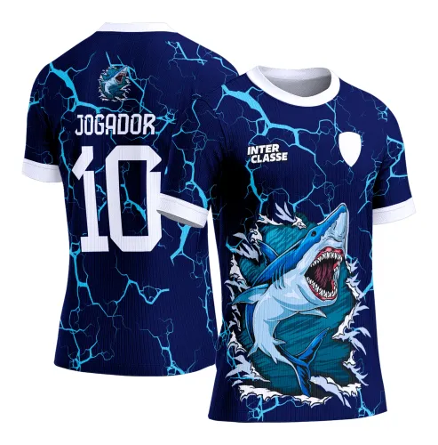Camisa azul escura com frente mostrando um tubarão em pose agressiva rompendo fundo, textos INTER CLASSE e escudo branco; costas com padrão de raios azuis, mini tubarão, texto JOGADOR e número 10 em branco.