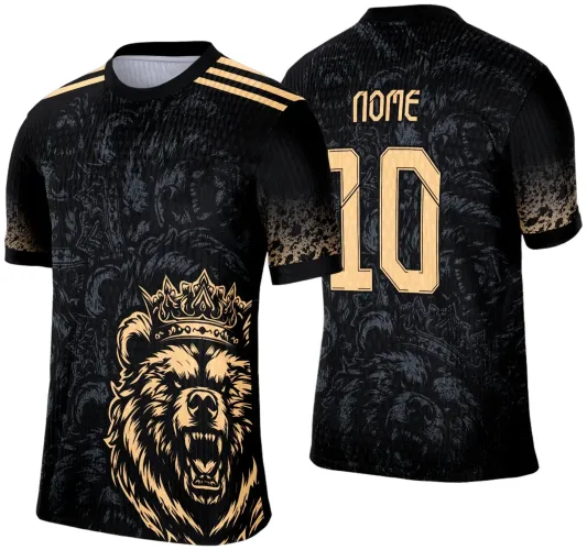 Camisa preta com estampa frontal de um urso rugindo com coroa dourada e degradê cinza. Costas exibem número 10 e texto 'NOME' em dourado, sobre fundo preto texturizado com detalhes florais e listras douradas nos ombros.