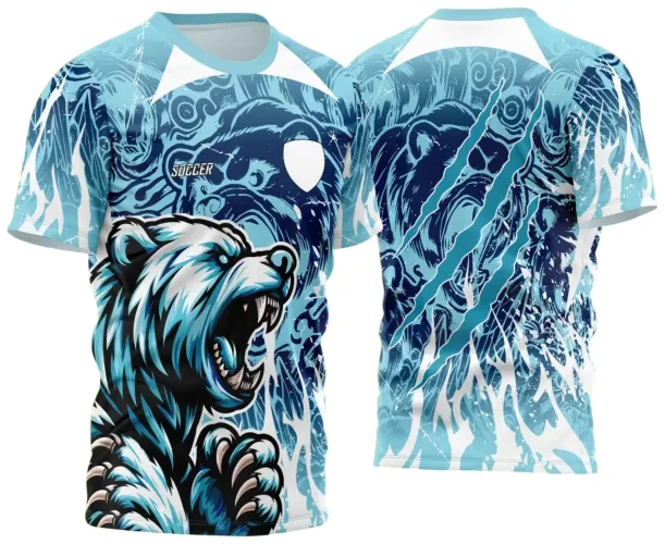 Camisa vibrante com figura frontal de um urso feroz azul em pose agressiva, escudo branco e texto 'SOCCER'. Costas com rosto do urso sombreado em azul com garras dinâmicas e fundo com efeitos de ondas e rachaduras em branco.