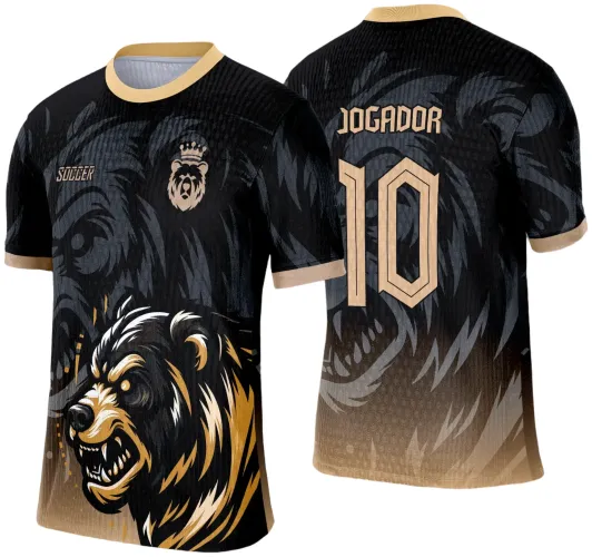 Camisa preta com detalhes dourados, frente com urso feroz em preto, branco e dourado, escudo de urso com coroa no peito e texto SOCCER; costas com nome JOGADOR e número 10 em dourado, fundo com padrão de urso em cinza escuro.