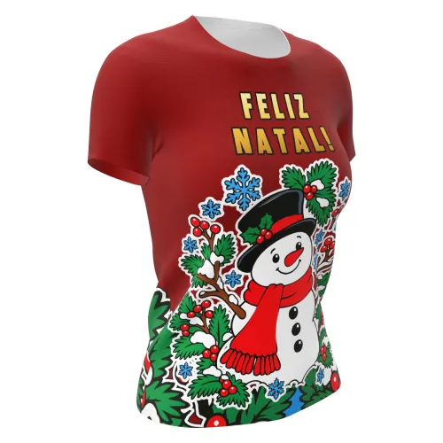 Camisa estampada por inteiro com fundo vermelho, boneco de neve sorridente na frente, galhos, folhas verdes, azevinhos, flocos de neve azuis e a frase FELIZ NATAL no peito.