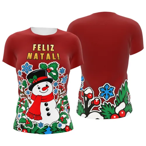 Camisa estampada por inteiro com fundo vermelho, boneco de neve sorridente na frente, galhos, folhas verdes, azevinhos, flocos de neve azuis e a frase FELIZ NATAL no peito.