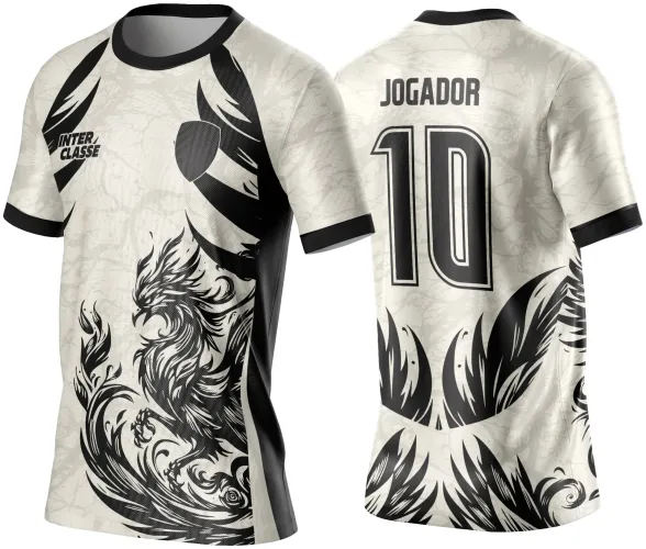 Camisa creme com estampa frontal de fênix tribal preta, faixa lateral preta, texto INTER CLASSE na frente; costas com número 10 grande preto e palavra JOGADOR acima, detalhes de penas estilizadas no final da camisa.