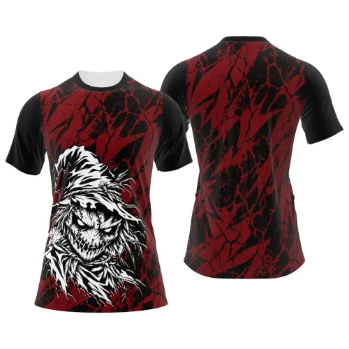 Camisa com estampa de espantalho assustador em destaque na frente, fundo preto com manchas e riscos vermelhos intensos cobrindo toda a peça, incluindo mangas e costas.