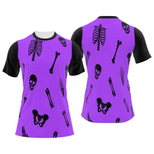 Camisa estampada por inteiro com fundo roxo, mangas pretas e desenhos de ossos, caveiras, costelas e mãos de esqueleto em preto, criando um visual marcante e divertido para Halloween.