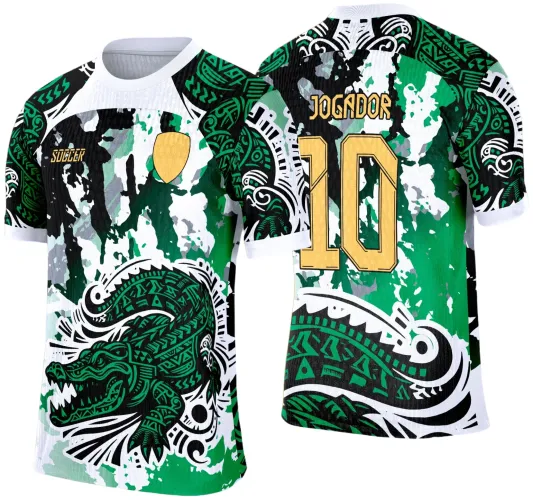 Camisa com arte de jacaré tribal verde na frente com fundo manchado em verde, preto e branco, escudo amarelo e texto 'SOCCER'. Nas costas numero 10 e texto 'JOGADOR' em amarelo com desenhos tribais semelhantes e fundo manchado.