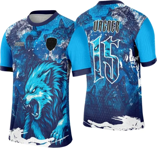 Camisa com lobo azul furioso estampado na frente, mangas azul claro e detalhes em branco e azul escuro. Nas costas, número 15 grande com texto VACER, fundo com figura de lobo e pintura branca estilizada.