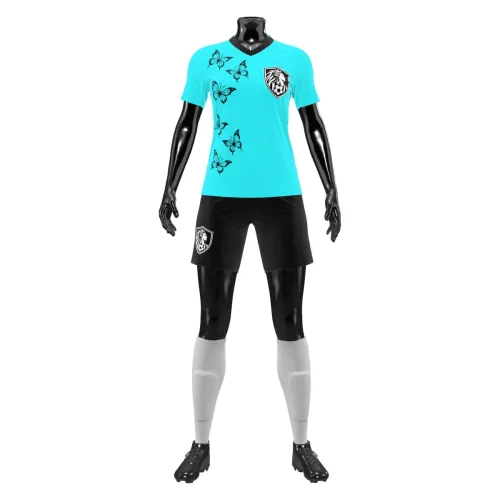 Camisa de futebol feminino em verde-água, com borboletas pretas delicadas na frente e nas costas, escudo estilizado no peito e número grande nas costas, cobrindo toda a peça.