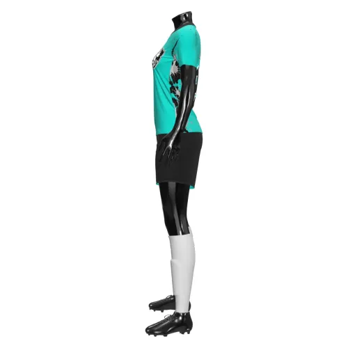 Camisa de futebol feminino com design moderno em verde e preto, detalhes de respingos artísticos e brasão estilizado na frente, cobrindo toda a peça, incluindo mangas e gola.