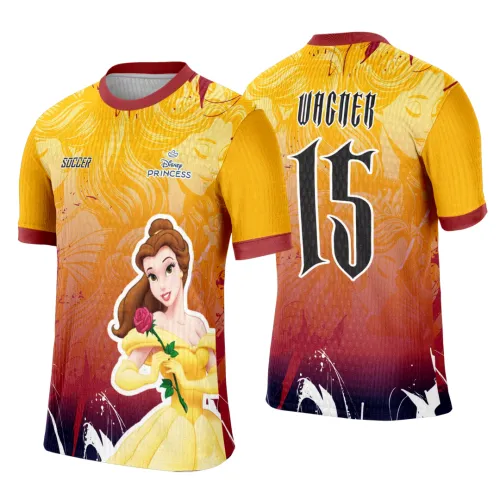Camisa feminina amarela e vermelha com estampa da Princesa Bela segurando uma rosa na frente; nas costas o número 15 e o nome VINCER em preto com contorno branco sobre fundo degradê. Palavras 'SOCCER' e 'Disney PRINCESS' aparecem na frente.