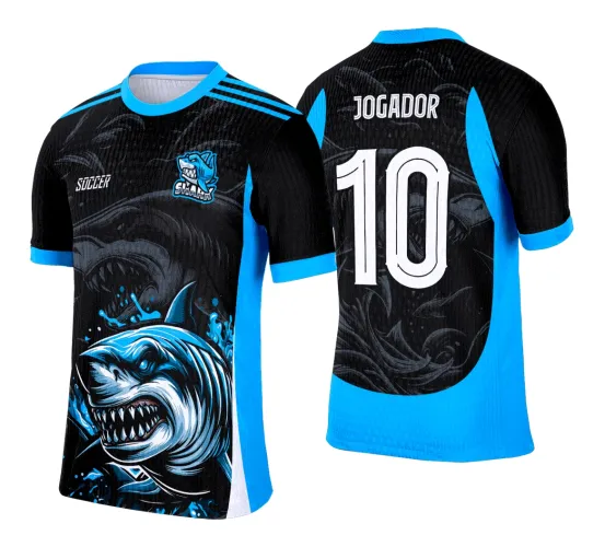 Camisa preta com azul claro, frente mostra tubarão agressivo em azul e branco com logo 'SHARK' e texto 'SOCCER', costas têm número grande branco 10 e texto 'JOGADOR' com fundo de ondas e tubarão em tons escuros.