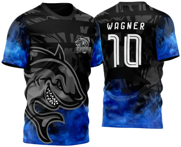 Camisa preta com degradê azul nas mangas e parte inferior, grande tubarão cinza com dentes à mostra na frente, escudo 'SHARK' no peito esquerdo, nome WAGNER e número 10 nas costas em branco com fundo preto e detalhes gráficos.