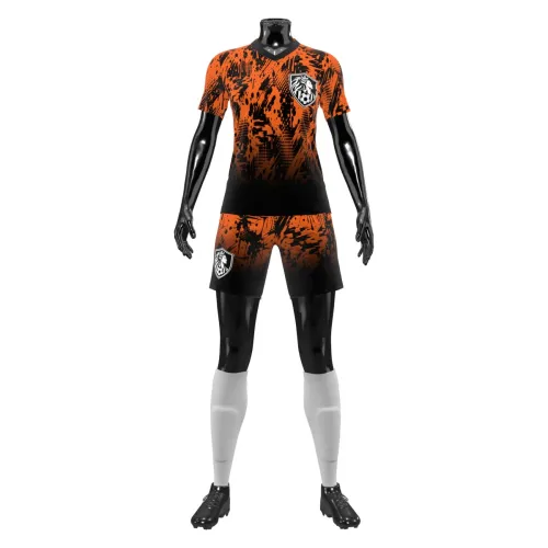 Camisa de futebol feminino com estampa laranja e preta em efeito splash, cobrindo frente, costas e mangas, com escudo estilizado e nome personalizado nas costas.