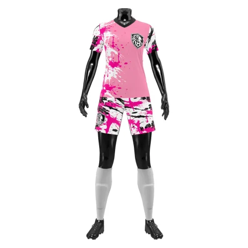 Camisa de futebol feminino com estampa grunge em rosa, preto e branco, cobrindo frente, costas e mangas, com detalhes de respingos e escudo estilizado.