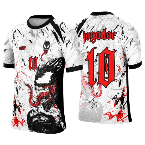 Camisa branca com estampa de Venom na frente, língua vermelha, número 10 em vermelho, detalhes de respingos vermelhos e pretos, gola e punhos pretos, texto 'SOCCER' na frente e 'jogador' nas costas com grande número 10 em vermelho.