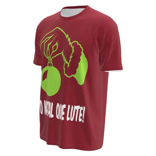 Camisa natalina vermelha com estampa frontal de mão peluda verde segurando uma bola de Natal e a frase O NATAL QUE LUTE, cobrindo toda a peça, incluindo mangas e gola.