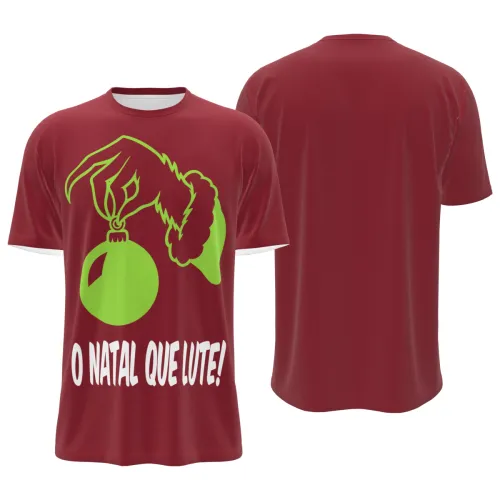 Camisa natalina vermelha com estampa frontal de mão peluda verde segurando uma bola de Natal e a frase O NATAL QUE LUTE, cobrindo toda a peça, incluindo mangas e gola.